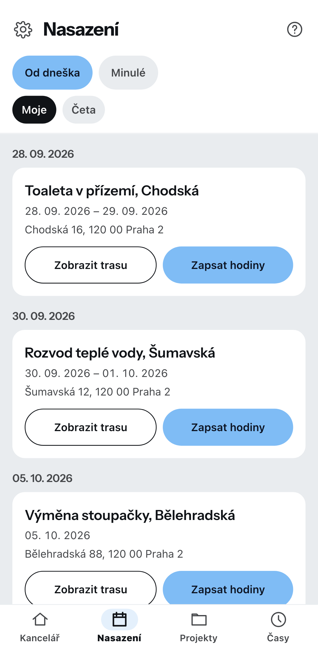 Nadcházející nasazení na telefonu, seskupená podle data: u každé položky zakázka a adresa stavby s tlačítky pro trasu a evidenci hodin, nahoře přepínače pro od dneška nebo minulá a pro moje nebo týmová.