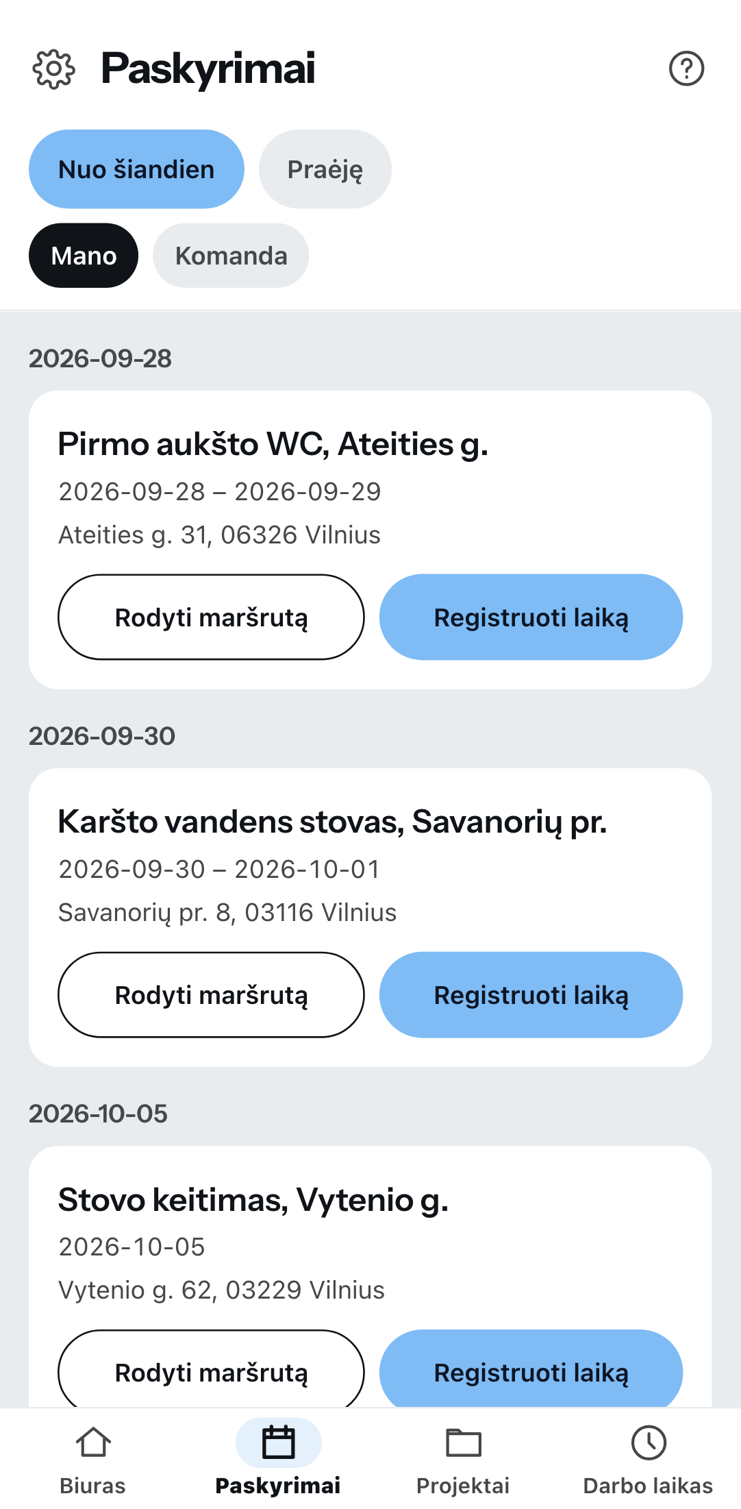Artėjančios užduotys telefone, sugrupuotos pagal datą: kiekviename įraše projektas ir statybvietės adresas su mygtukais maršrutui ir darbo laikui, viršuje perjungikliai nuo šiandien arba praėjusios ir mano arba komandos.