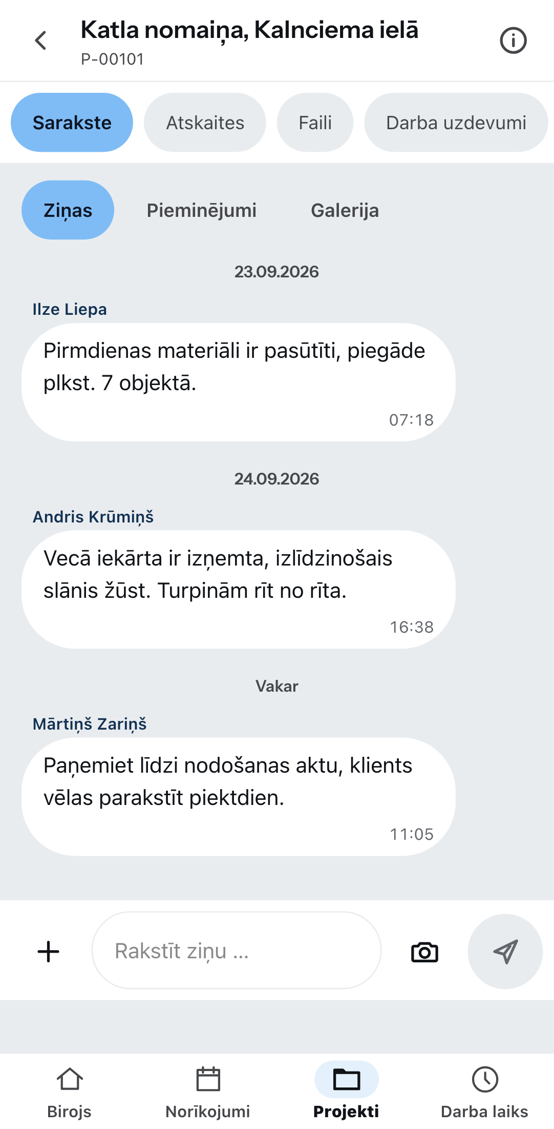 Projekta tērzēšana telefonā: augšā cilnes Tērzēšana, Pārskati, Glabātuve un Darba norādījumi, zem tām ziņas, pieminējumi un galerija, trīs ziņas ar vārdu un laiku, apakšā ievades lauks ar kameras pogu.