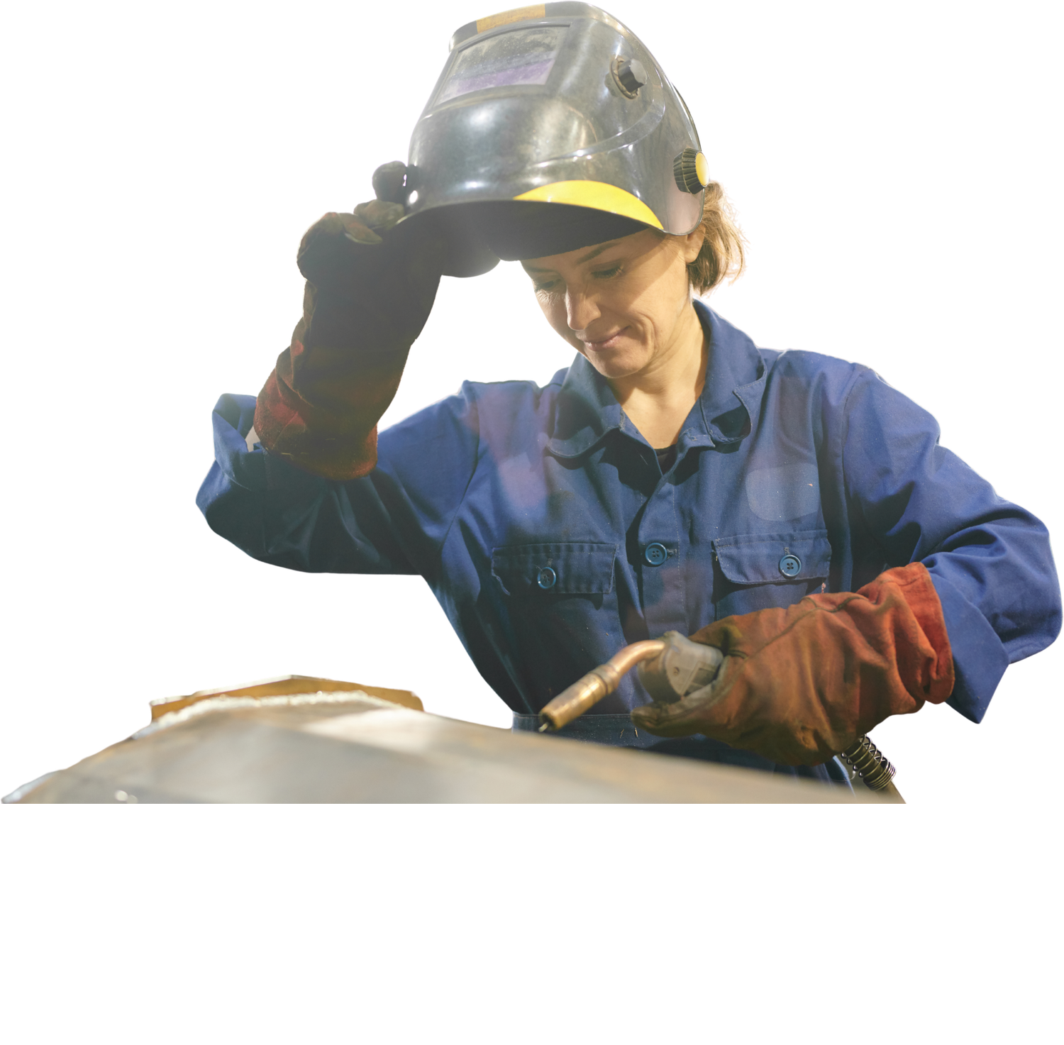Schweißerin im blauen Overall klappt den Schweißhelm hoch und hält den Brenner über das Werkstück.